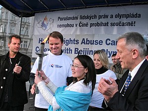 Miss Xinxia Jiang receives the torch from Martin Bursik Minister of Environment while MP Katerina Jacques look on