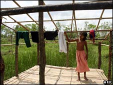 A young girl dries clothes on the damaged roof of her home in Twantay on 29 May 2008