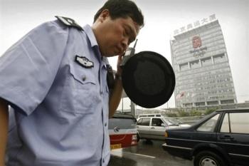 A Beijing policeman uses his radio as they question foreign journalists